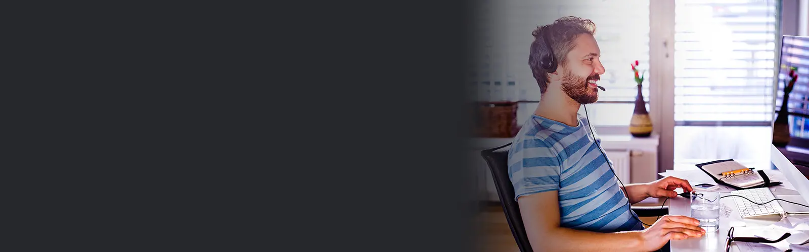 Man in striped shirt working at desk at home