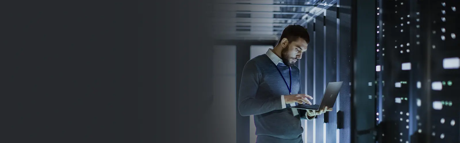 Man on laptop in server room