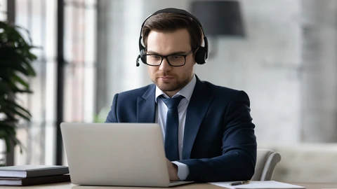 Man with headset on and working on computer 