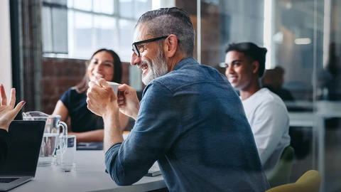 Happy Co-workers gather around office table