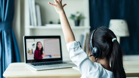 Girl raising hand during virtual school lesson