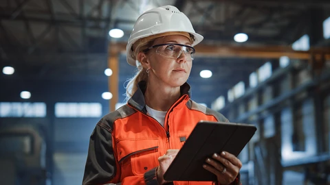 Women in hardhat holding electronic tablet