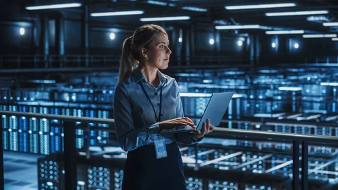 Woman holding laptop in data center