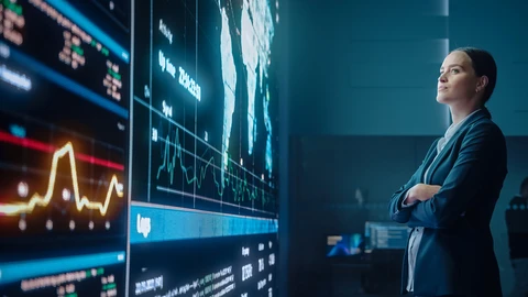 Executive woman standing in front of room size monitors
