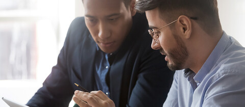2 people reviewing data over a tablet