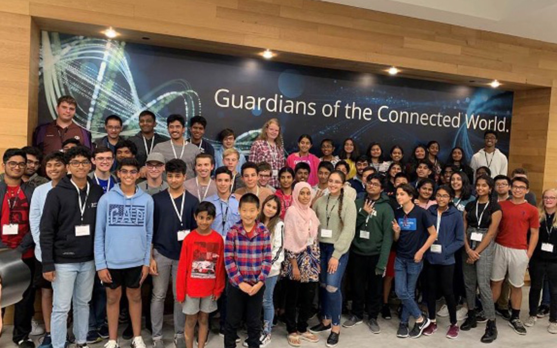 Large group of teenage boys and girls standing with NETSCOUT volunteers