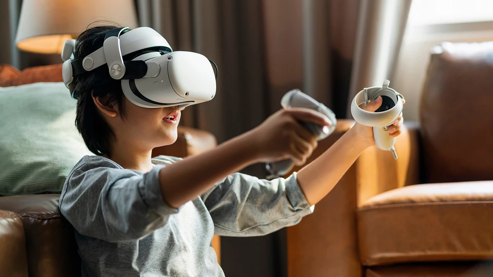 Child sitting with back up against a piece of furniture using virtual reality system